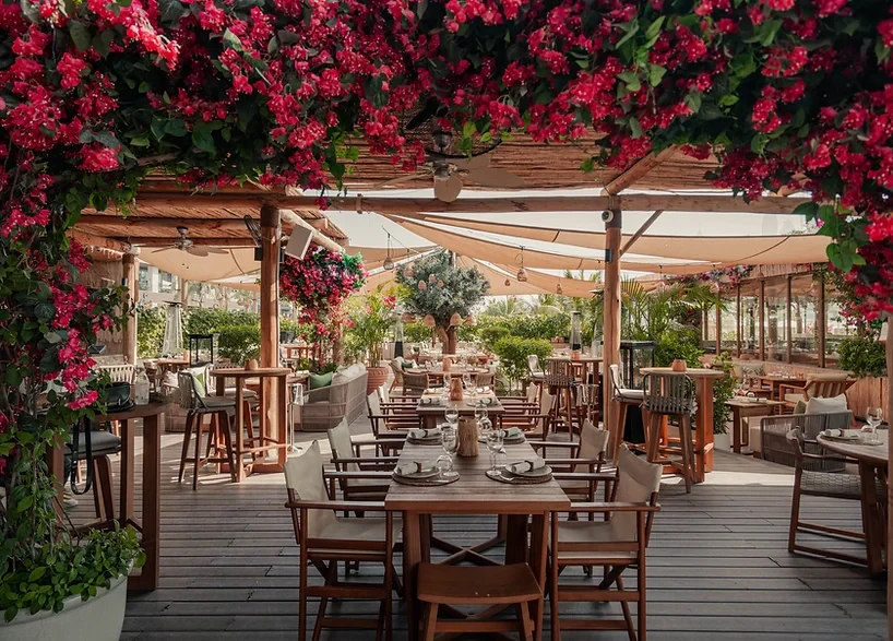 Outdoor dining area at Surf Club Dubai with floral decorations.