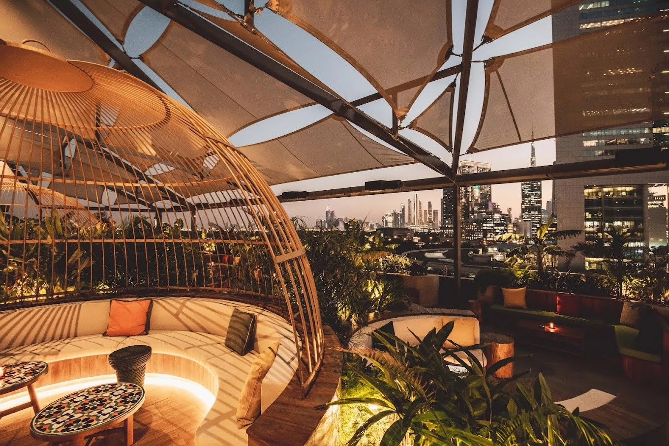 Stylish rooftop seating at Monkey Bar Dubai with city skyline view.