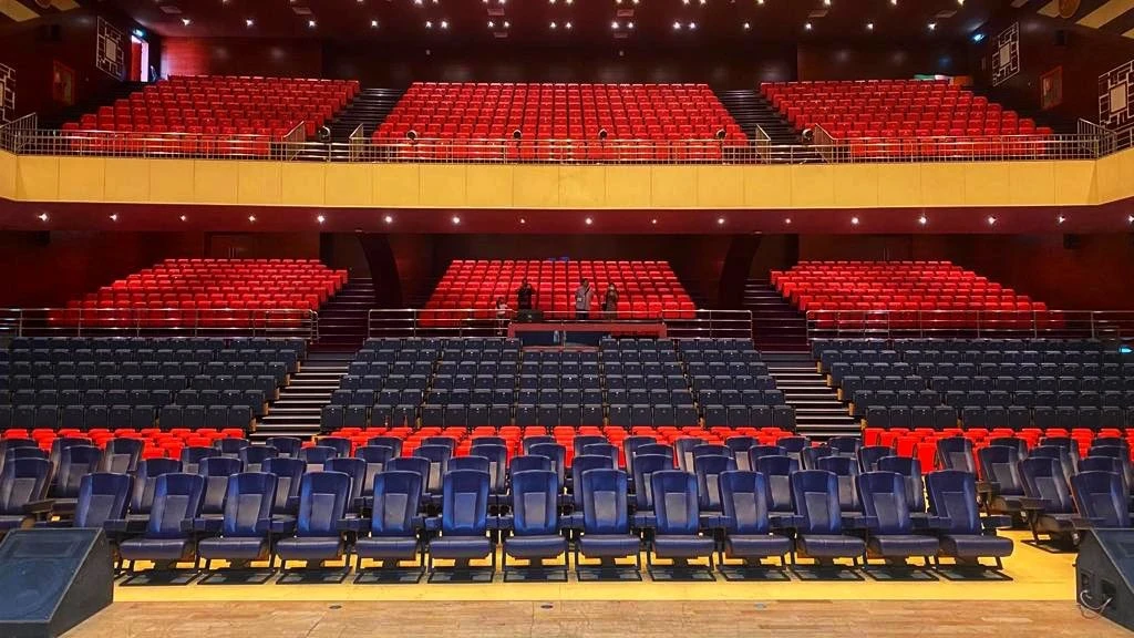 Sheikh Rashid Auditorium seating, Dubai, with red and blue chairs.