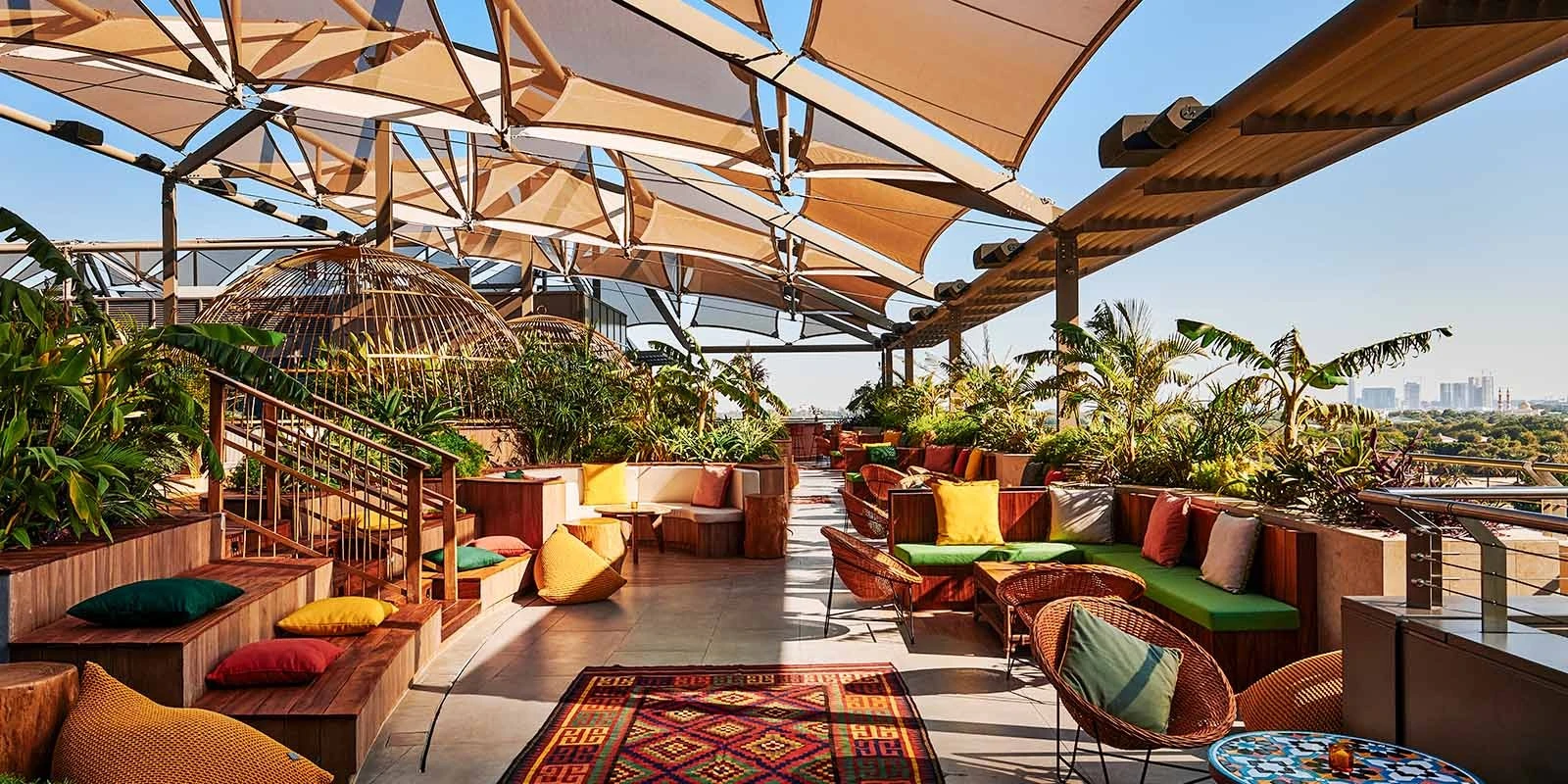 Colorful rooftop seating at Monkey Bar Dubai with city view.