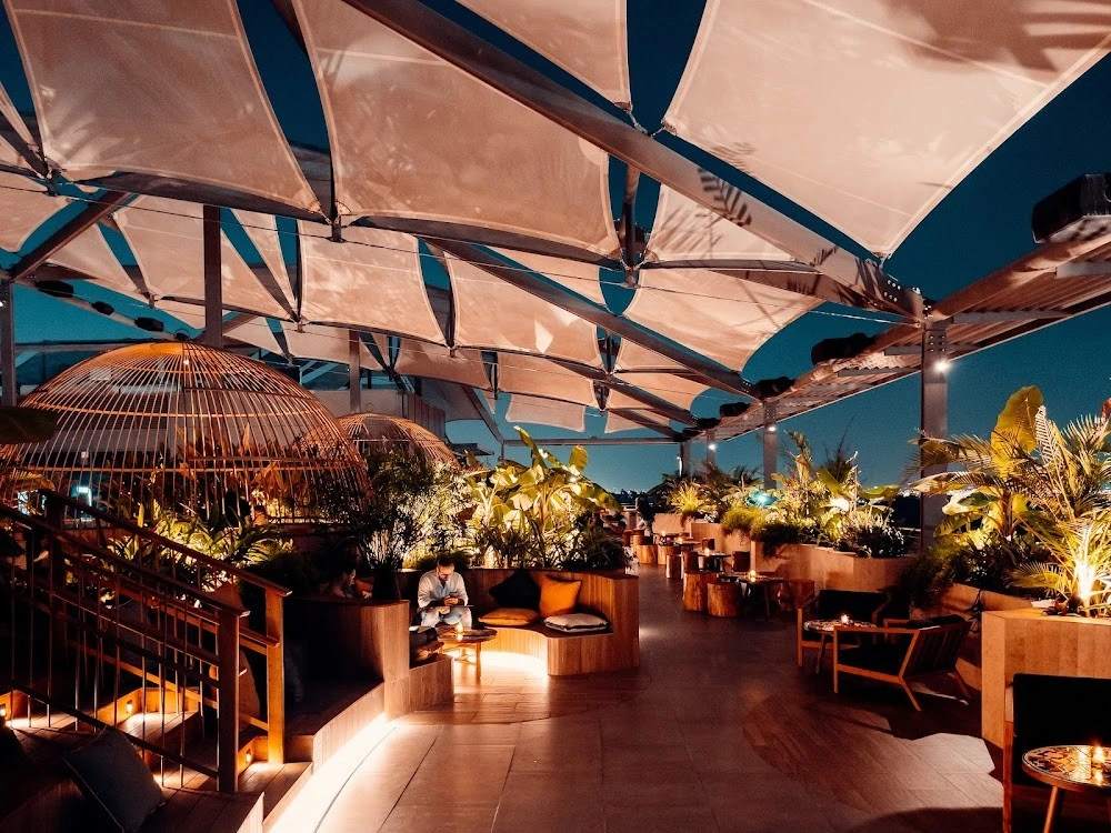 Stylish rooftop lounge with plants and seating at Monkey Bar Dubai.