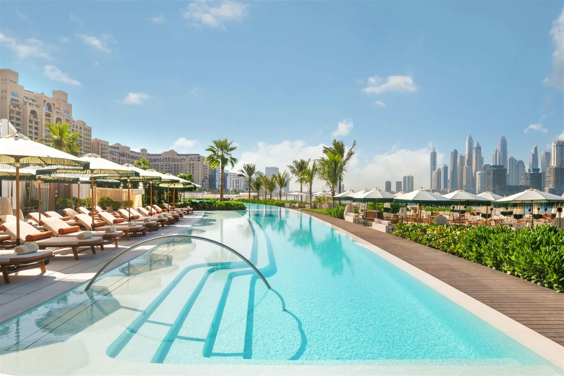 EVA Beach Restaurant poolside with Dubai skyline in background.