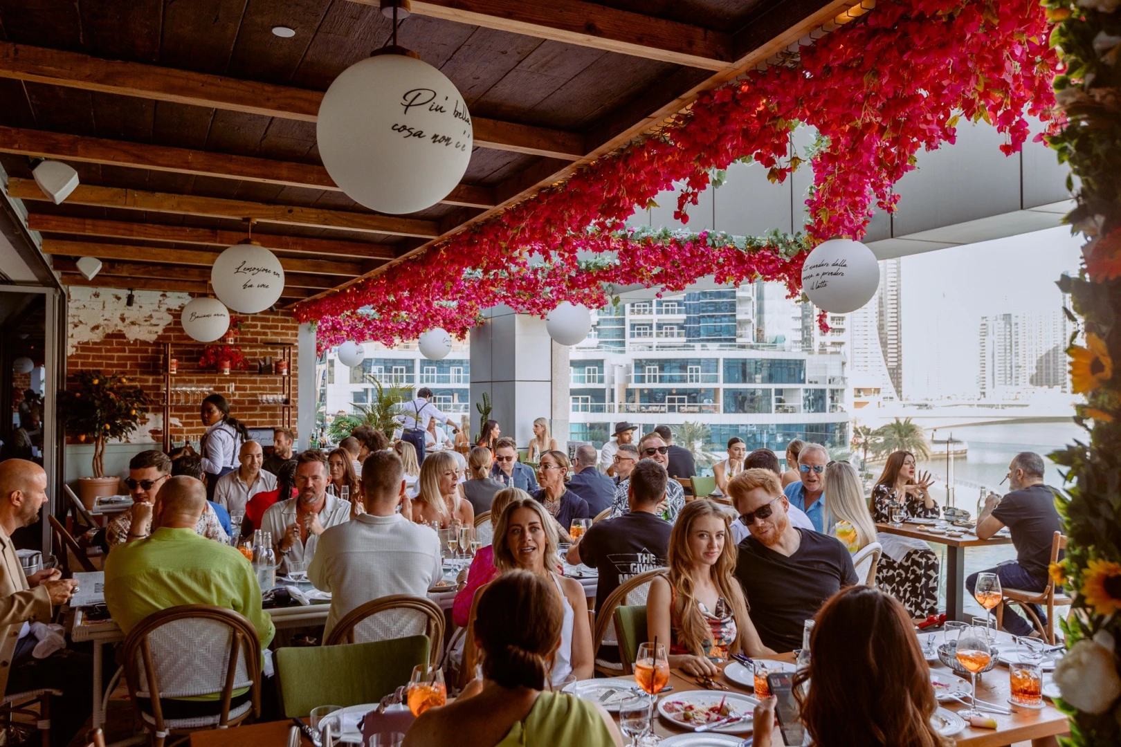 Crowded terrace dining at Papas Dubai Marina with waterfront view.