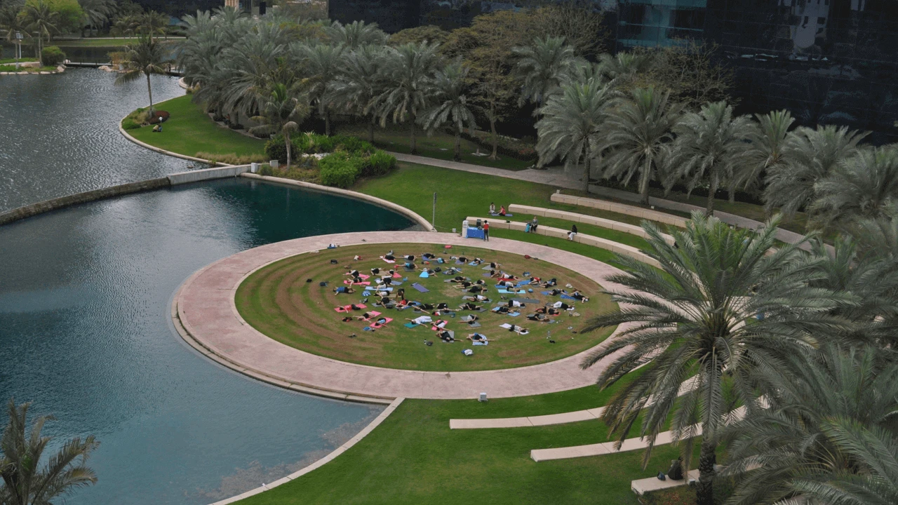 Dubai Media City Amphitheatre with people relaxing on grass