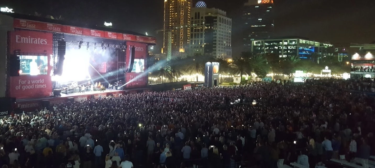 Concert crowd at Dubai Media City Amphitheatre, night view.