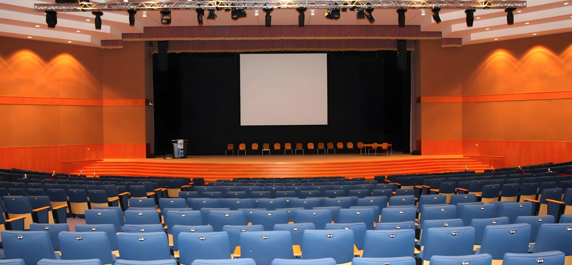 Hct Dubai Al-Nahda Campus Auditorium with blue seats and stage.
