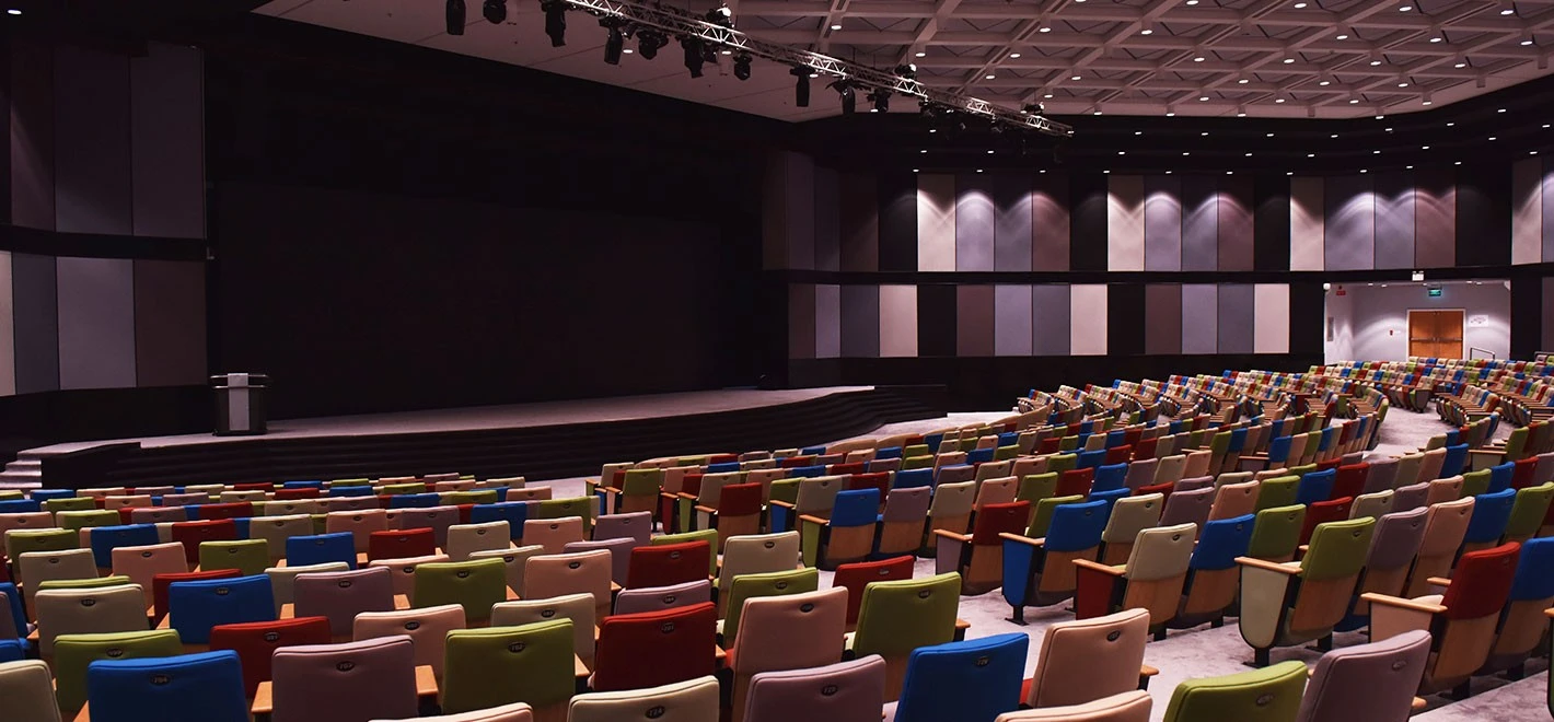 Colorful auditorium seats at HCT Dubai Al-Nahda Campus.