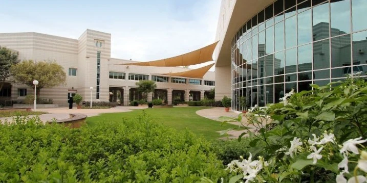 HCT Dubai Al-Nahda Campus Auditorium exterior with garden view.