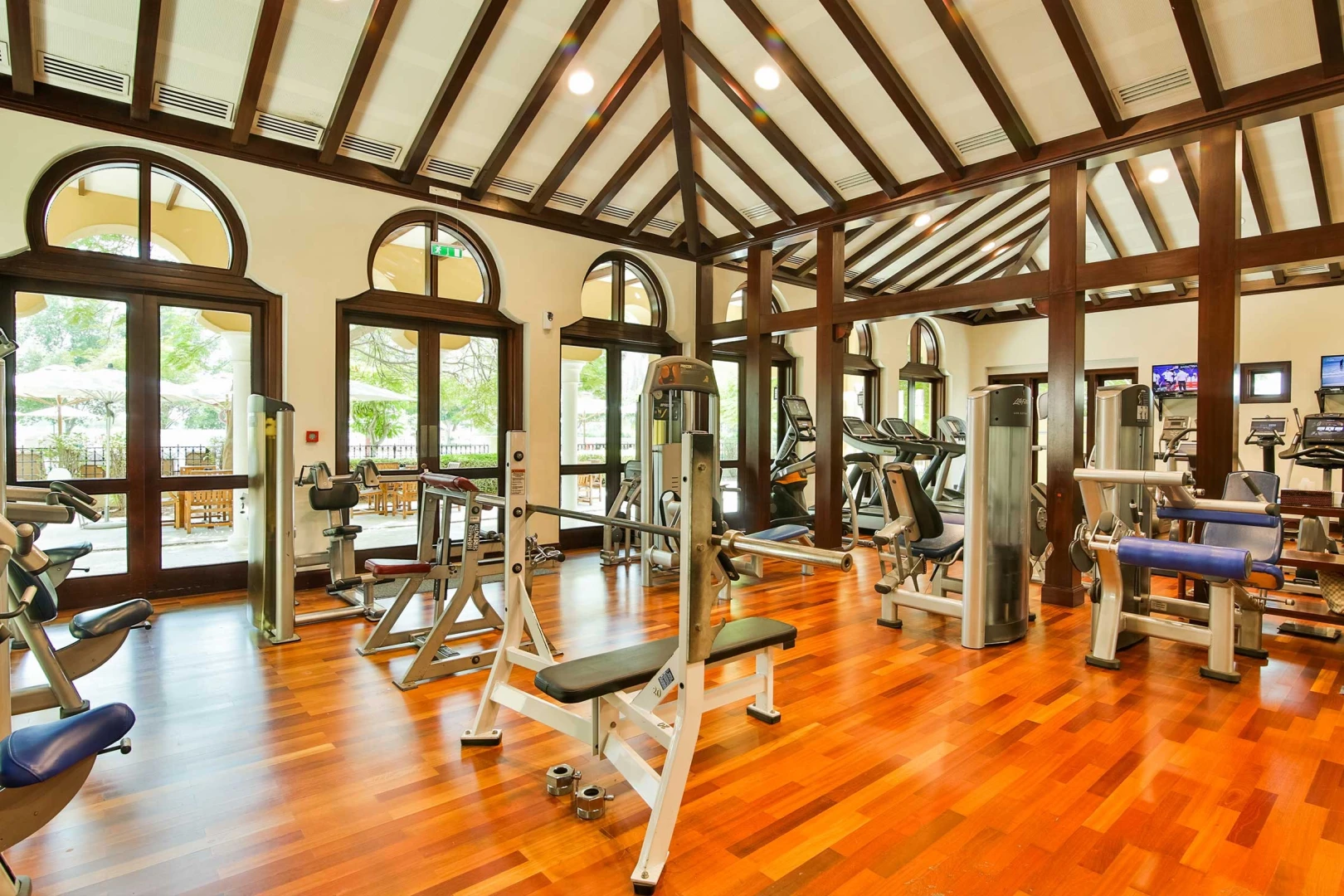 Dubai Polo & Equestrian Club gym with equipment and wooden flooring.