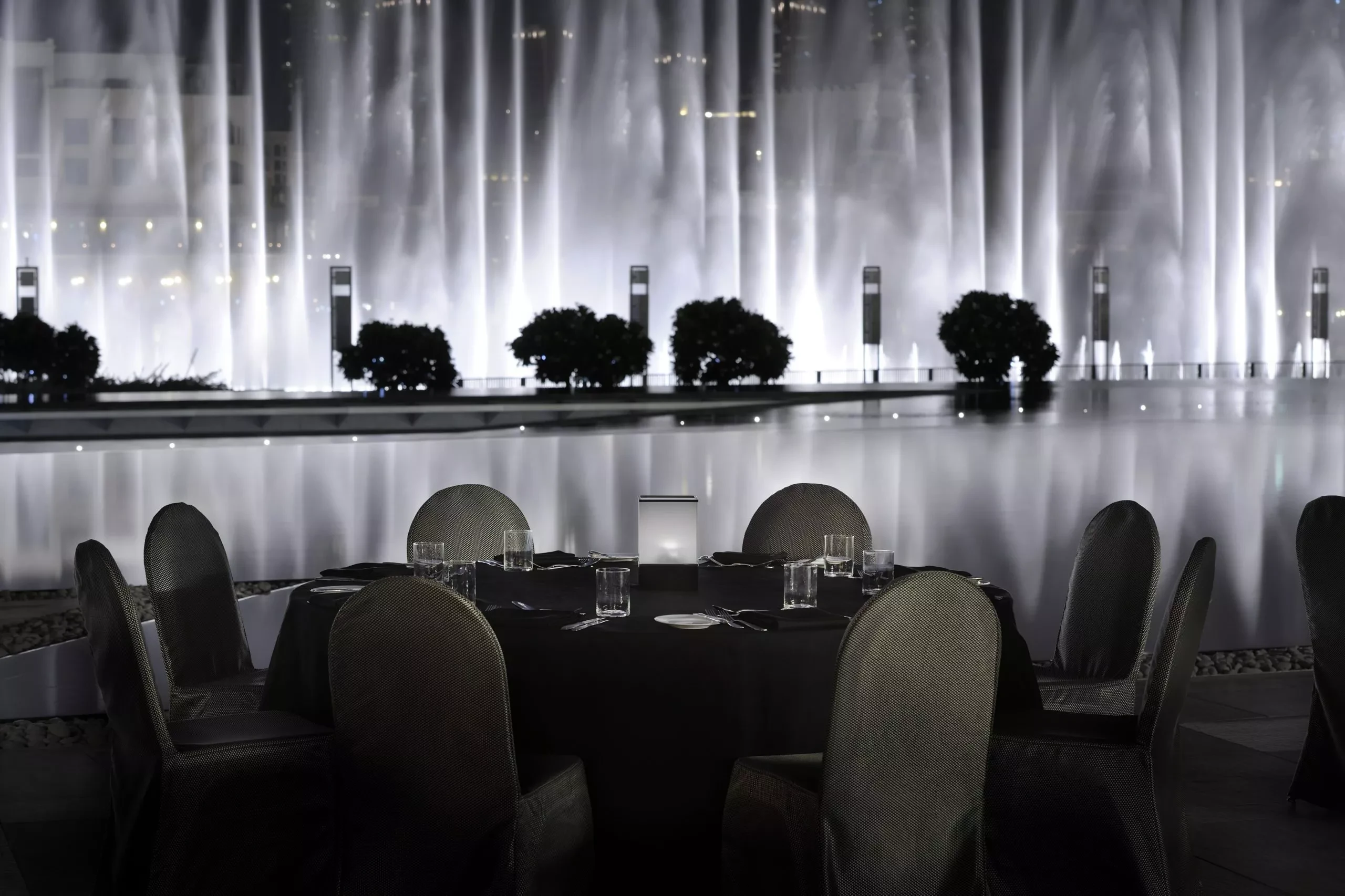 Elegant dining setup at Armani Hotel Dubai with illuminated fountains.