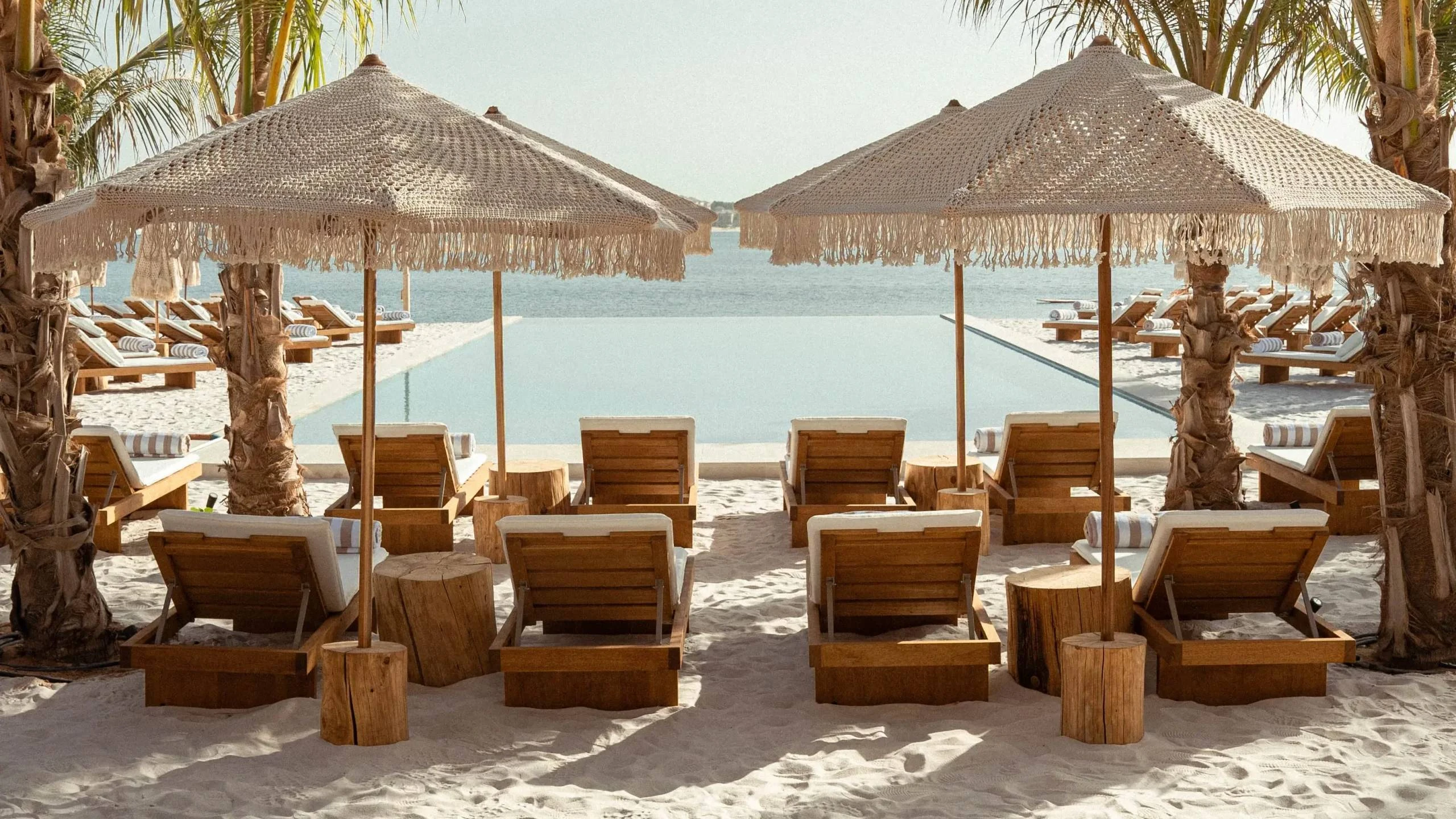 Kyma Beach Dubai sun loungers, umbrellas, and infinity pool view.