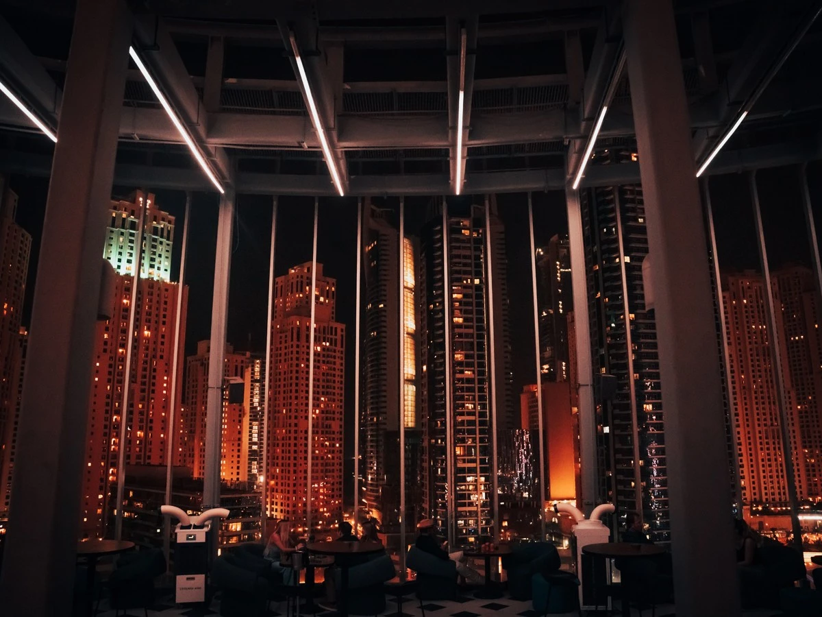 Atelier M rooftop view of Dubai skyscrapers at night.
