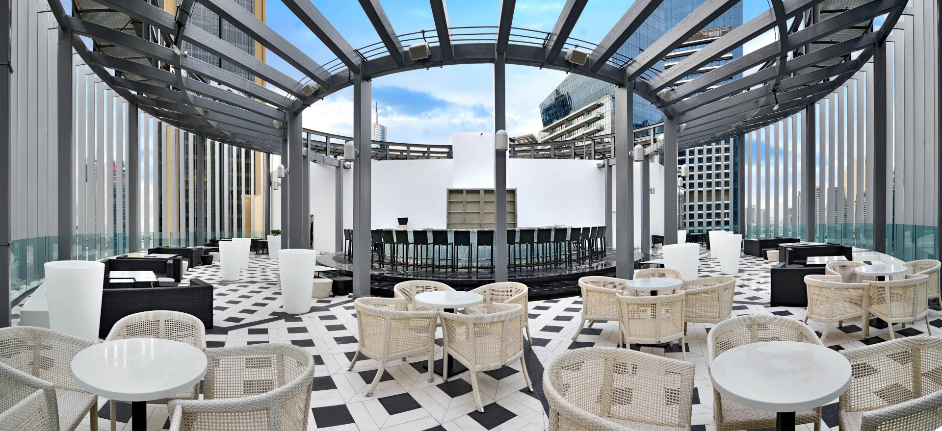 Atelier M rooftop terrace with seating, Dubai skyline view.