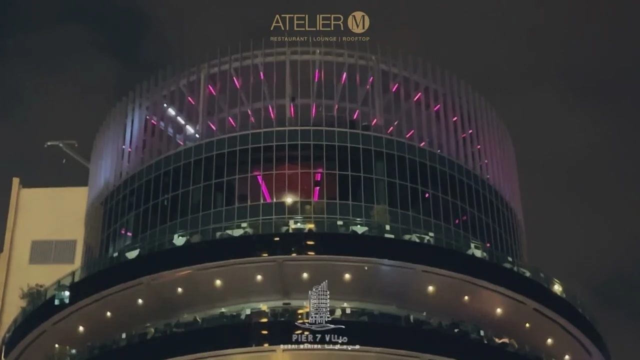 Atelier M rooftop with pink lights, Dubai night view.
