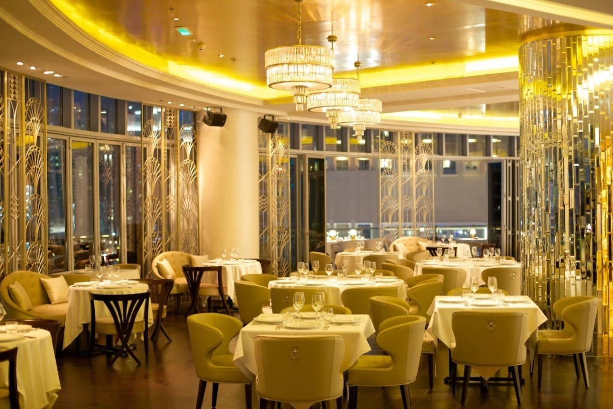 Sophisticated dining room at Atelier M, Dubai with golden chandeliers.