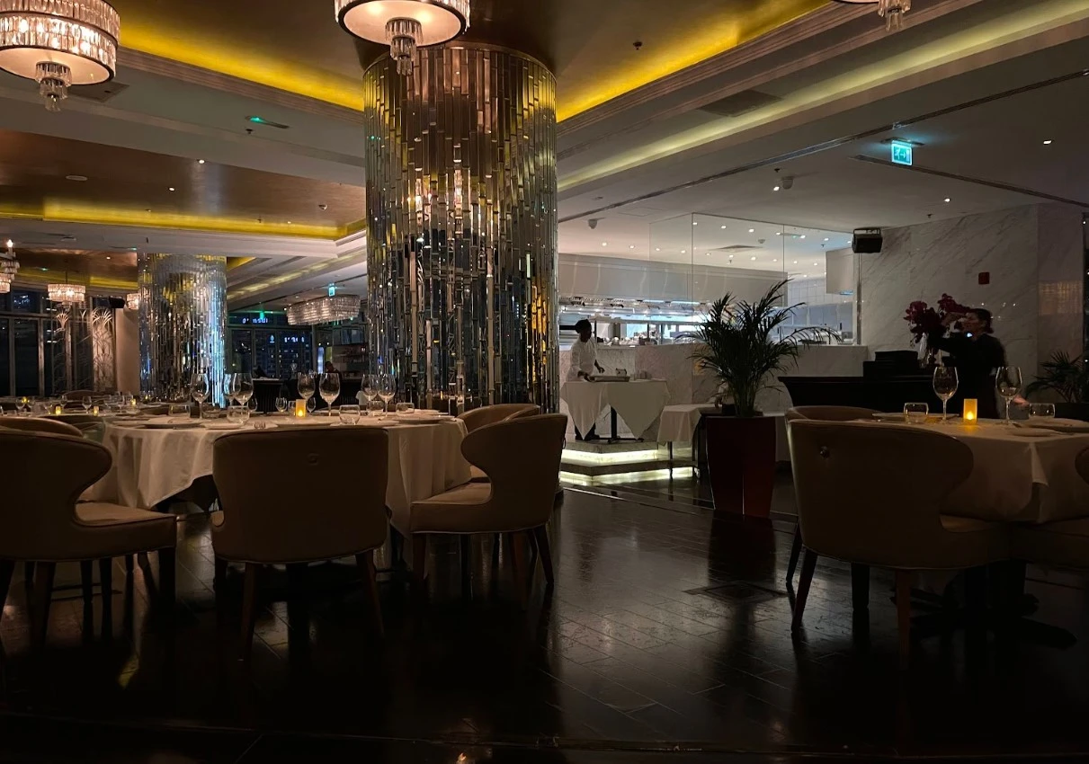 Elegant dining area at Atelier M, Dubai with chandeliers and tables.