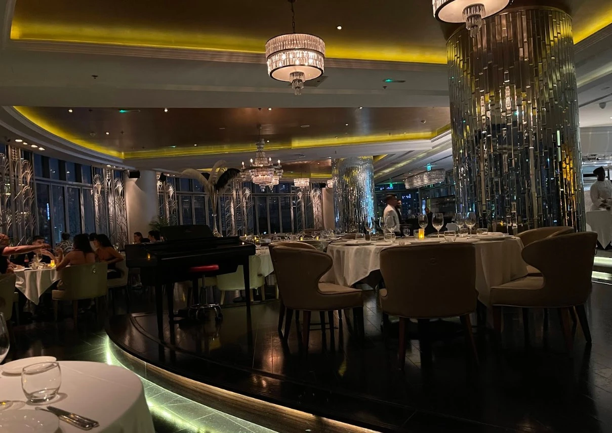 Sophisticated dining room at Atelier M, Dubai with chandeliers and piano.