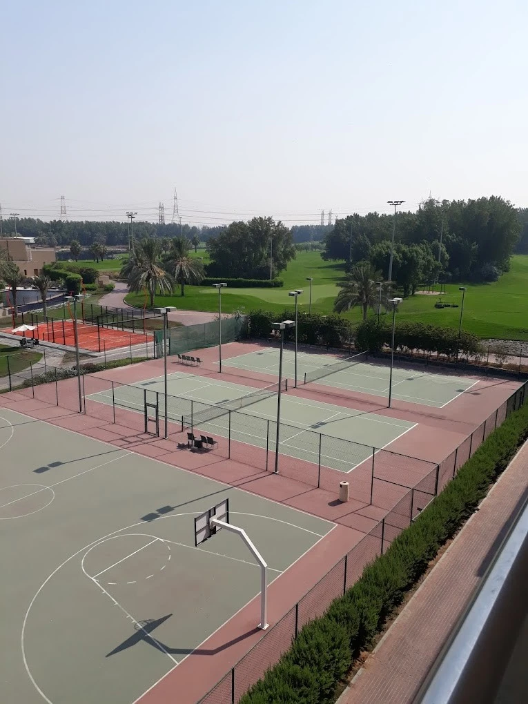 Sharjah Golf and Shooting Club sports courts, surrounded by greenery.