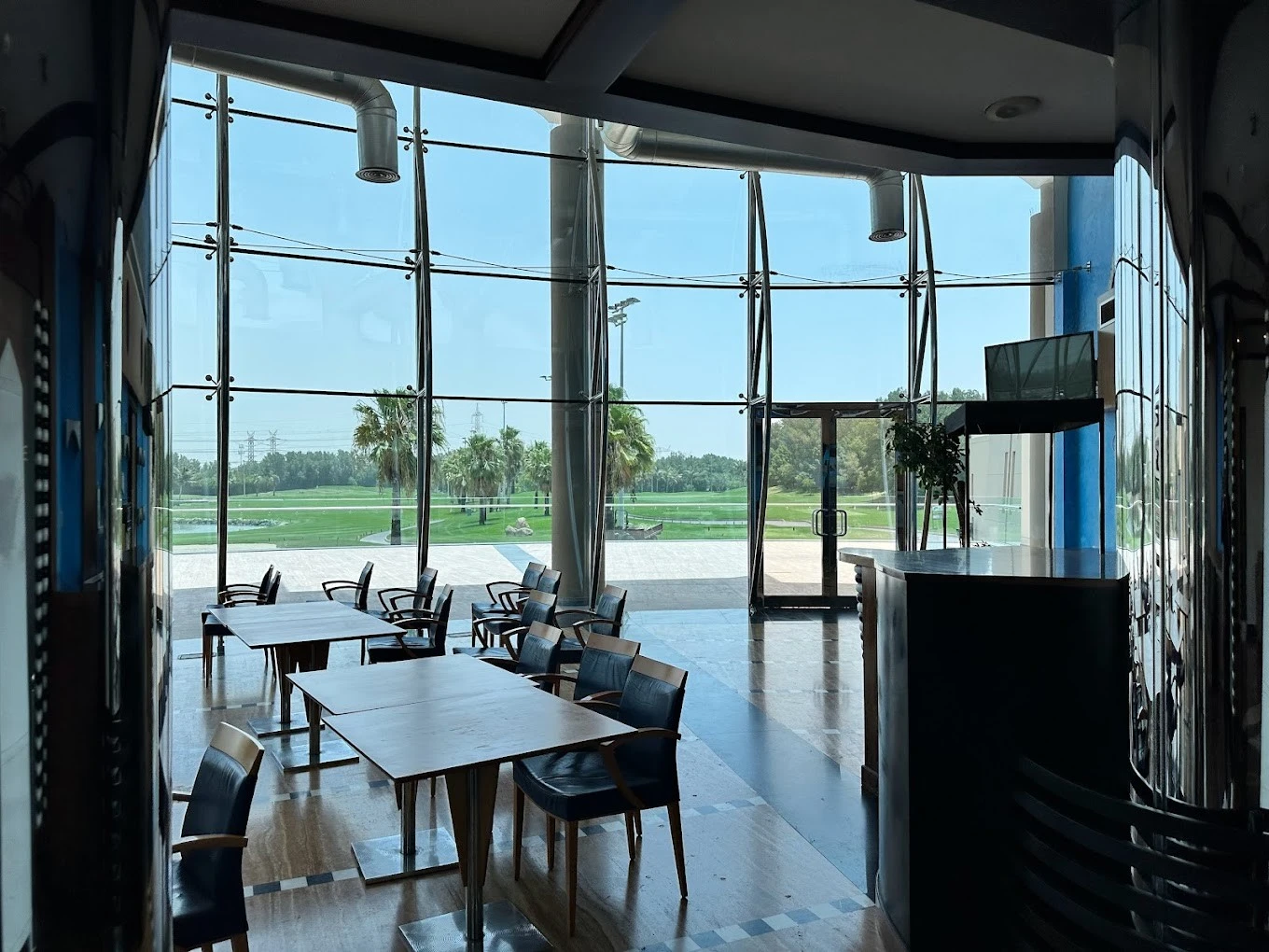 Interior of Sharjah Golf and Shooting Club overlooking green landscape.