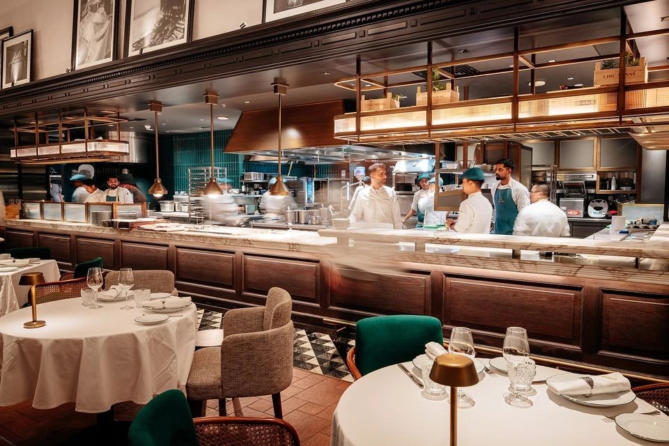 Chic Nonna Dubai restaurant interior with chefs in open kitchen.