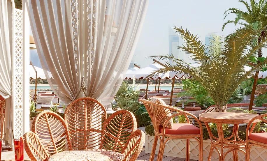 Maison de La Plage outdoor seating with palm trees, Dubai.