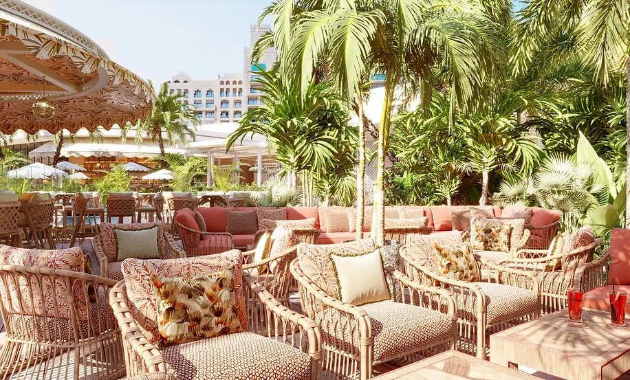 Outdoor seating at Maison de La Plage, Dubai, surrounded by palm trees.