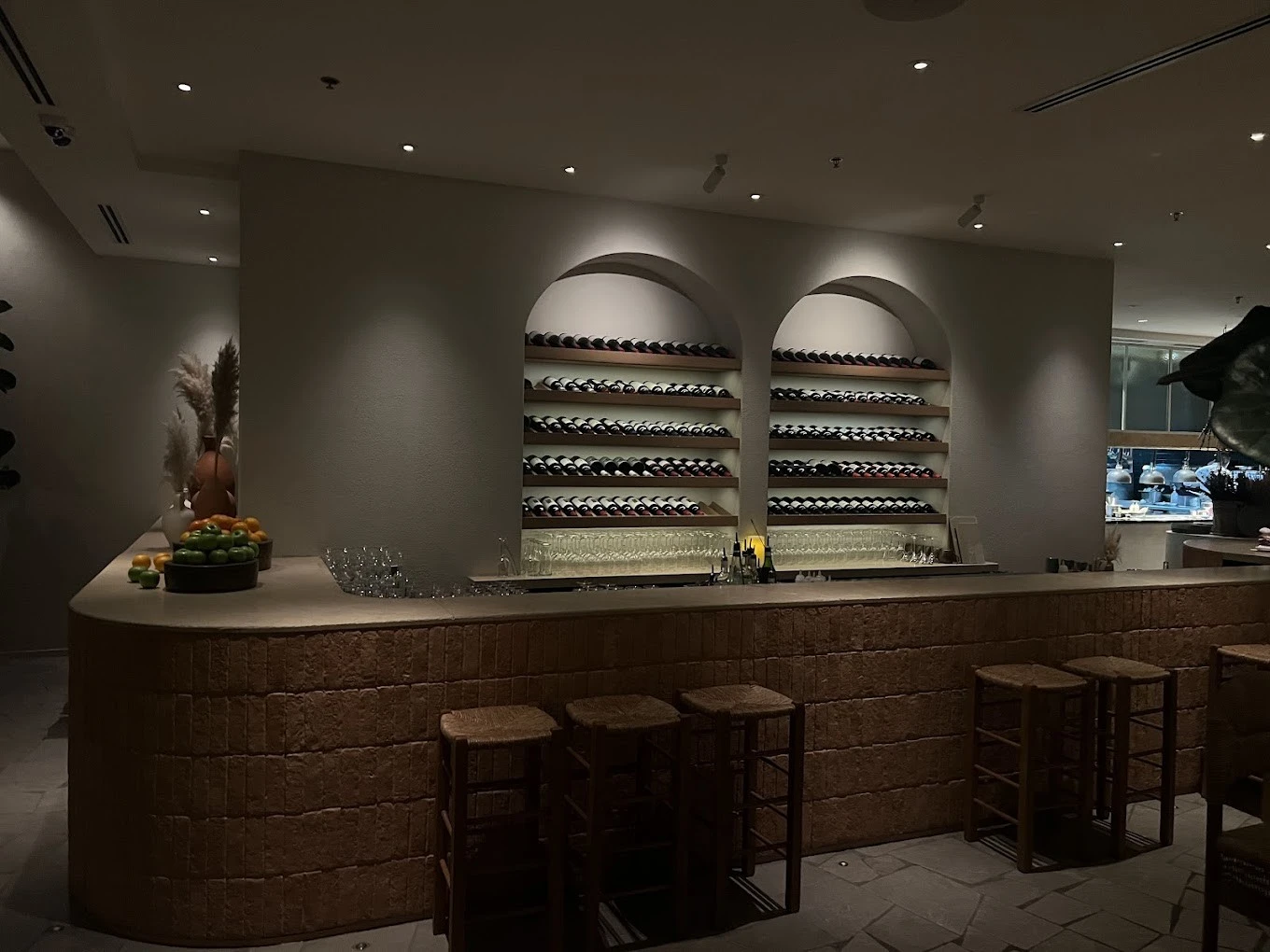 Elegant bar with wine shelves at Mythos Urban Greek Eatery, Dubai.