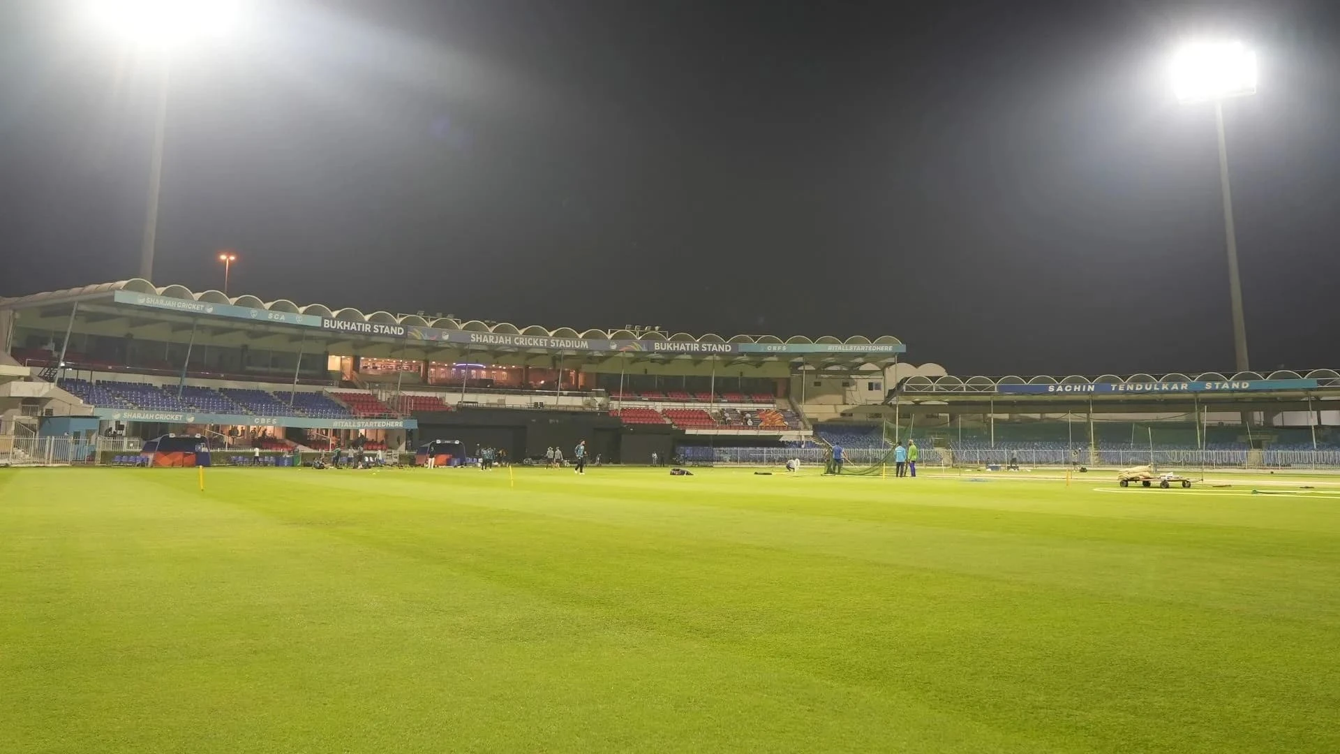 Sharjah Cricket Stadium at night with illuminated stands and field