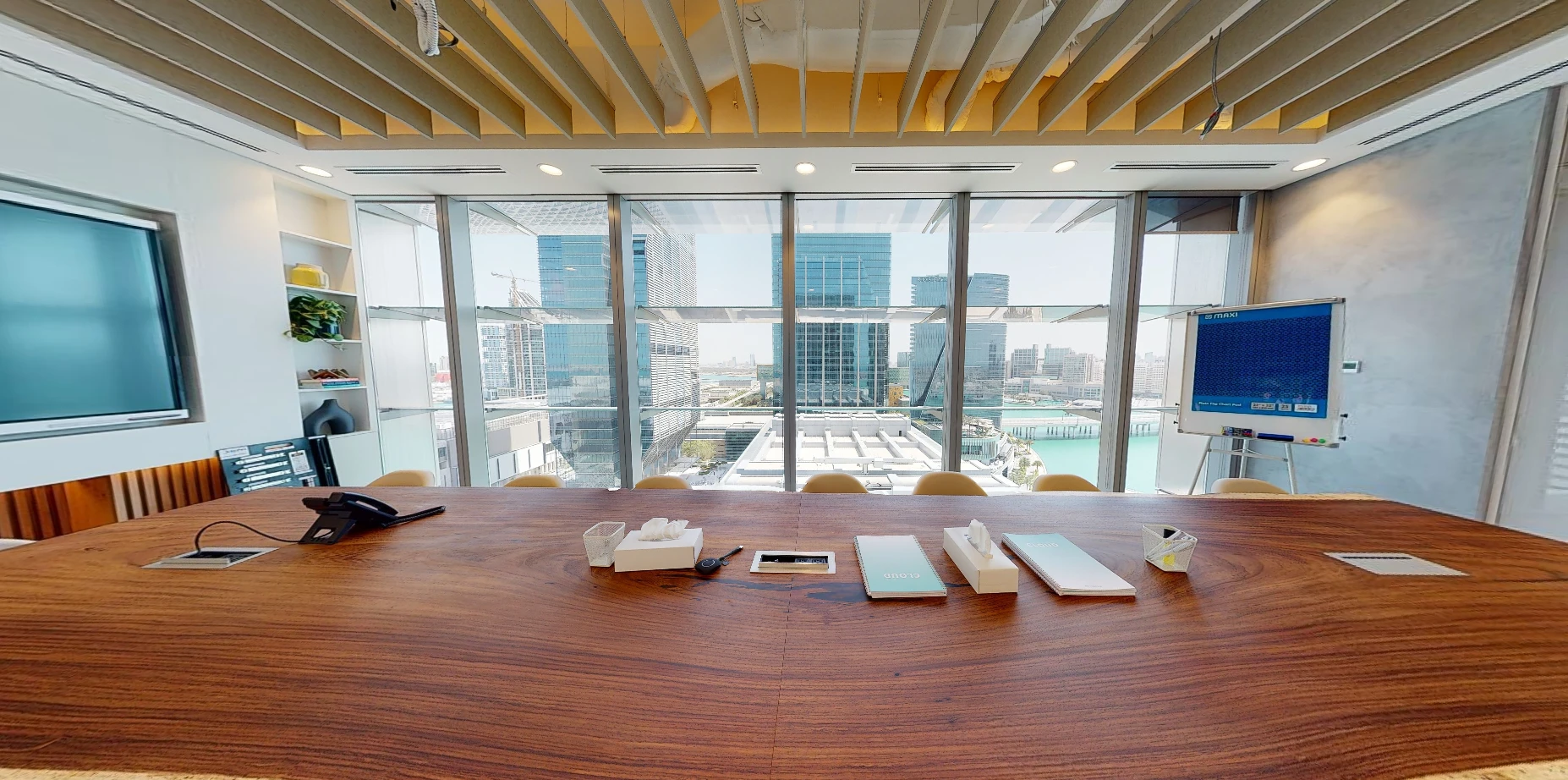 Conference room with wooden table and skyline view, Cloud Spaces ADGM.