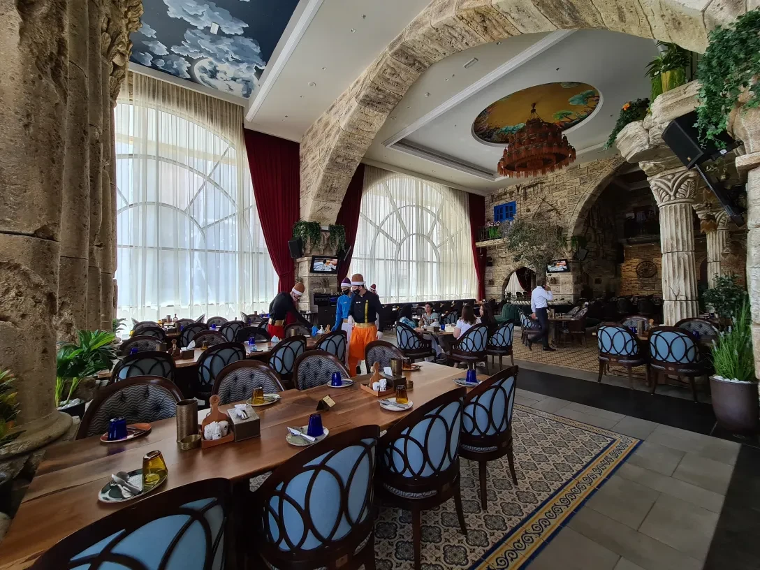 Elegant dining area at Al Meshwar Restaurant, Dubai with stone arches.