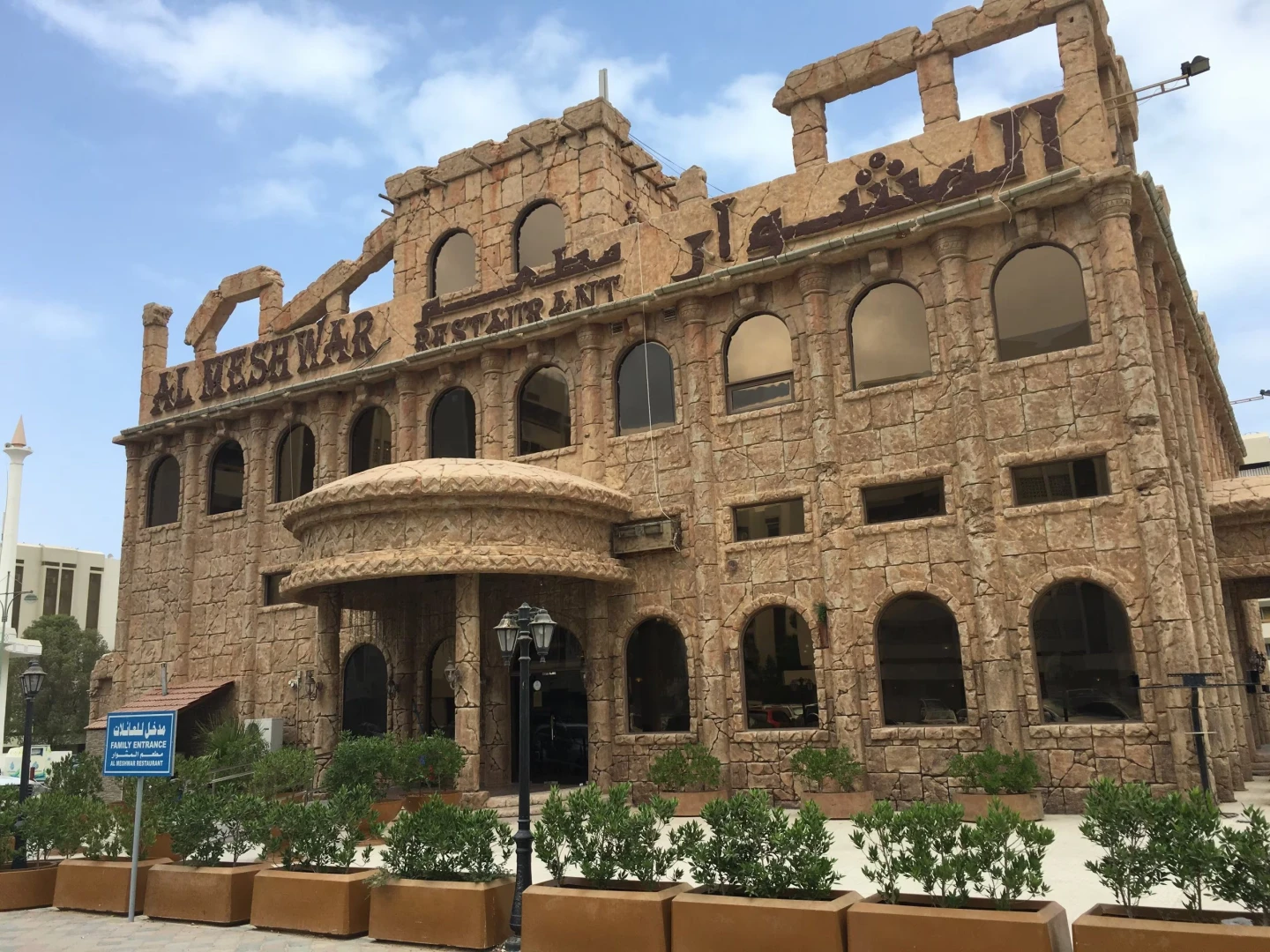 Al Meshwar Restaurant's stone facade in Dubai with arched windows.