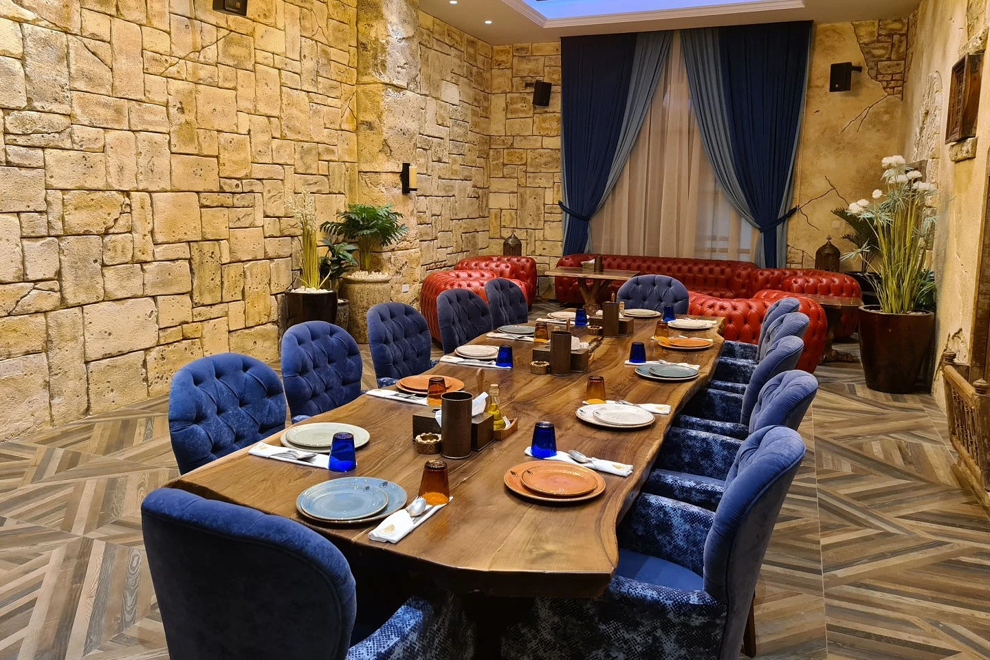 Elegant dining setup at Al Meshwar Restaurant, Dubai with stone walls.