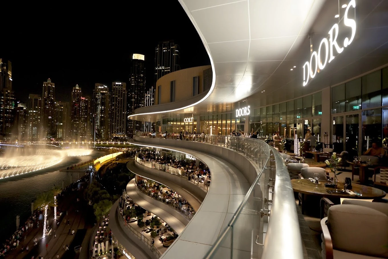 Doors Dubai Mall Restaurant overlooking city skyline and fountain at night.