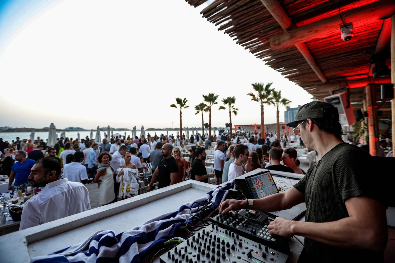 DJ performing at Surf Club Dubai, crowded beachside venue.