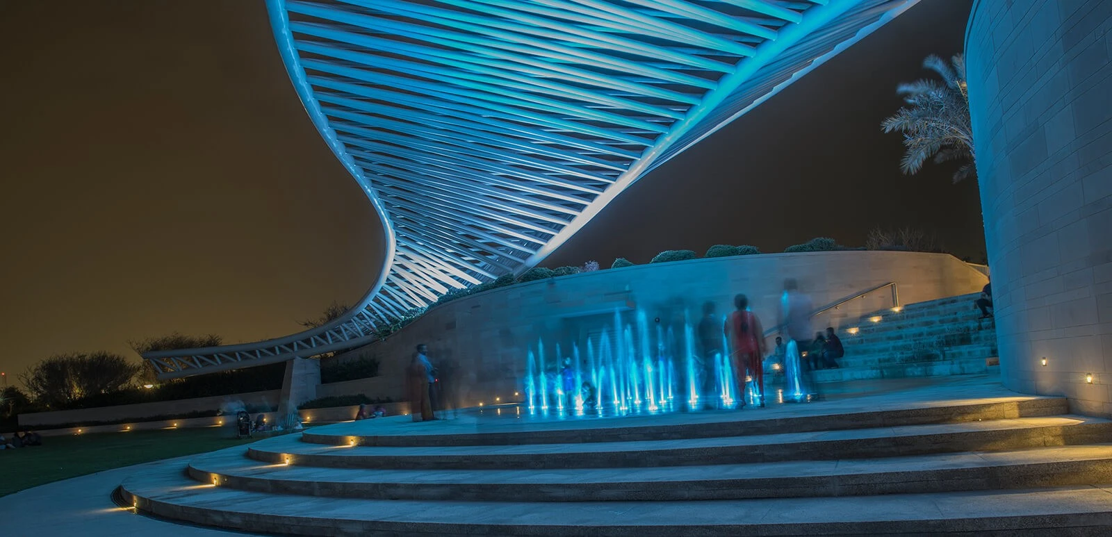 Umm Al Emarat Park amphitheatre with blue lighting, Abu Dhabi night scene.