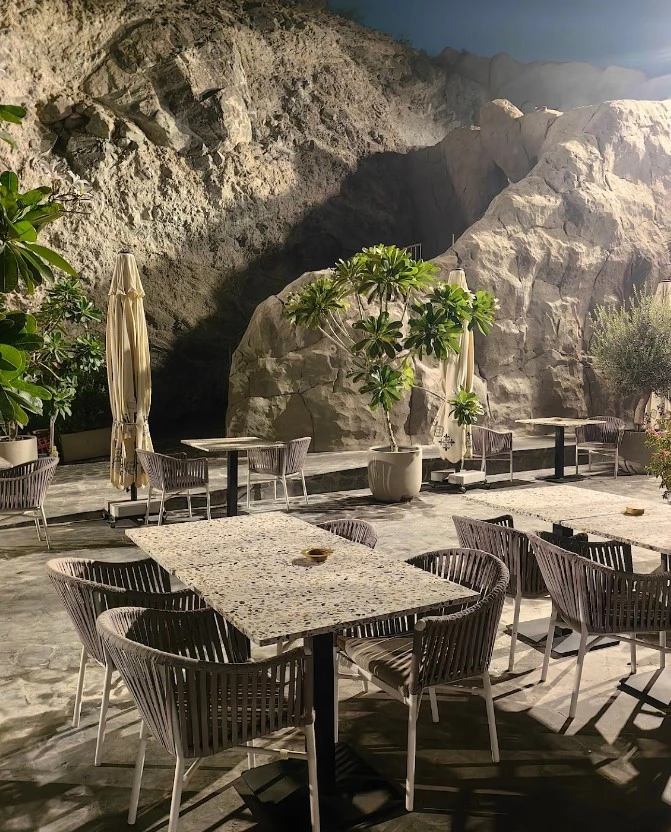 Outdoor seating at Habib Beirut Restaurant Khorfakkan, Sharjah, with rocky backdrop.