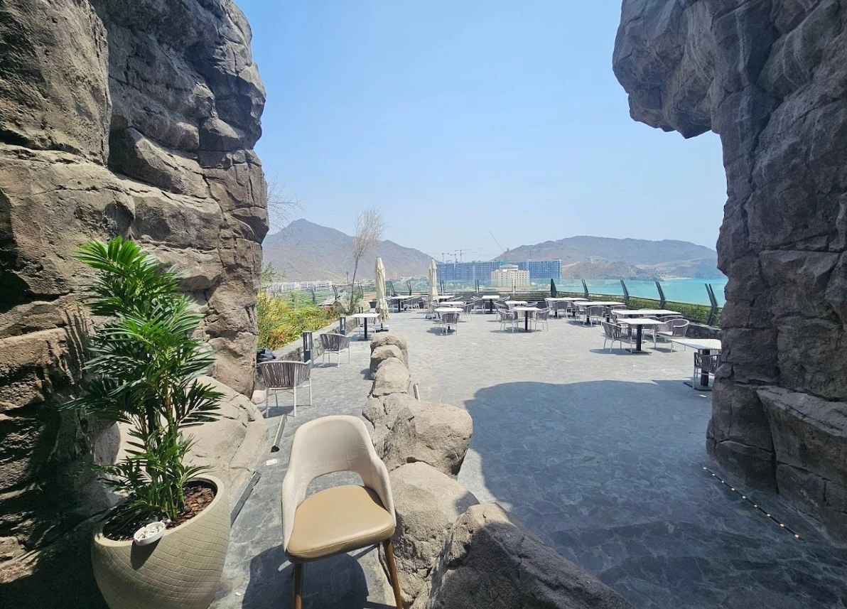 Outdoor seating at Habib Beirut Restaurant, Khorfakkan, overlooking mountains and sea.