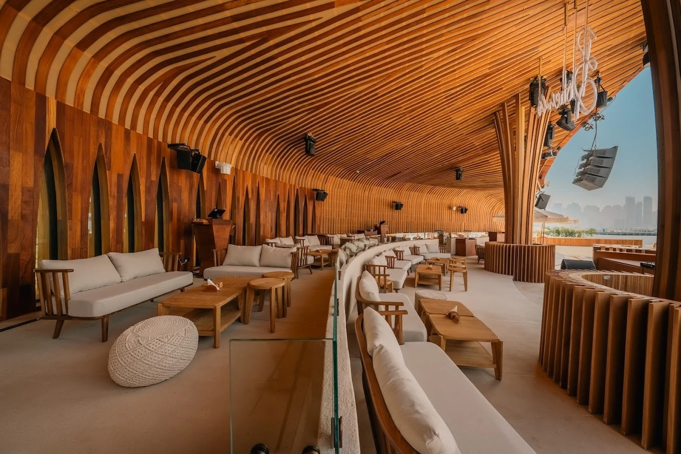 Bohemia Beach Club Dubai lounge with wooden decor and city view.