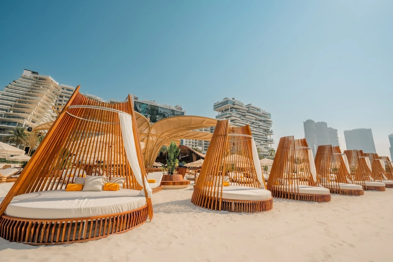 Luxury cabanas at Bohemia Beach Club Dubai on sandy beach.