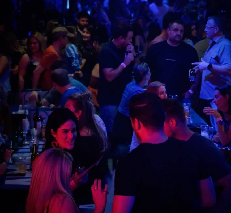 Crowded P7 Arena in Dubai with people socializing under blue lights.