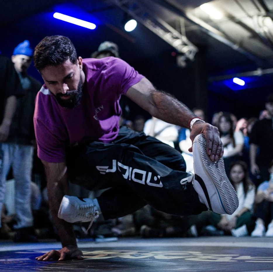 Breakdancer performing at P7 Arena, Dubai, surrounded by audience.