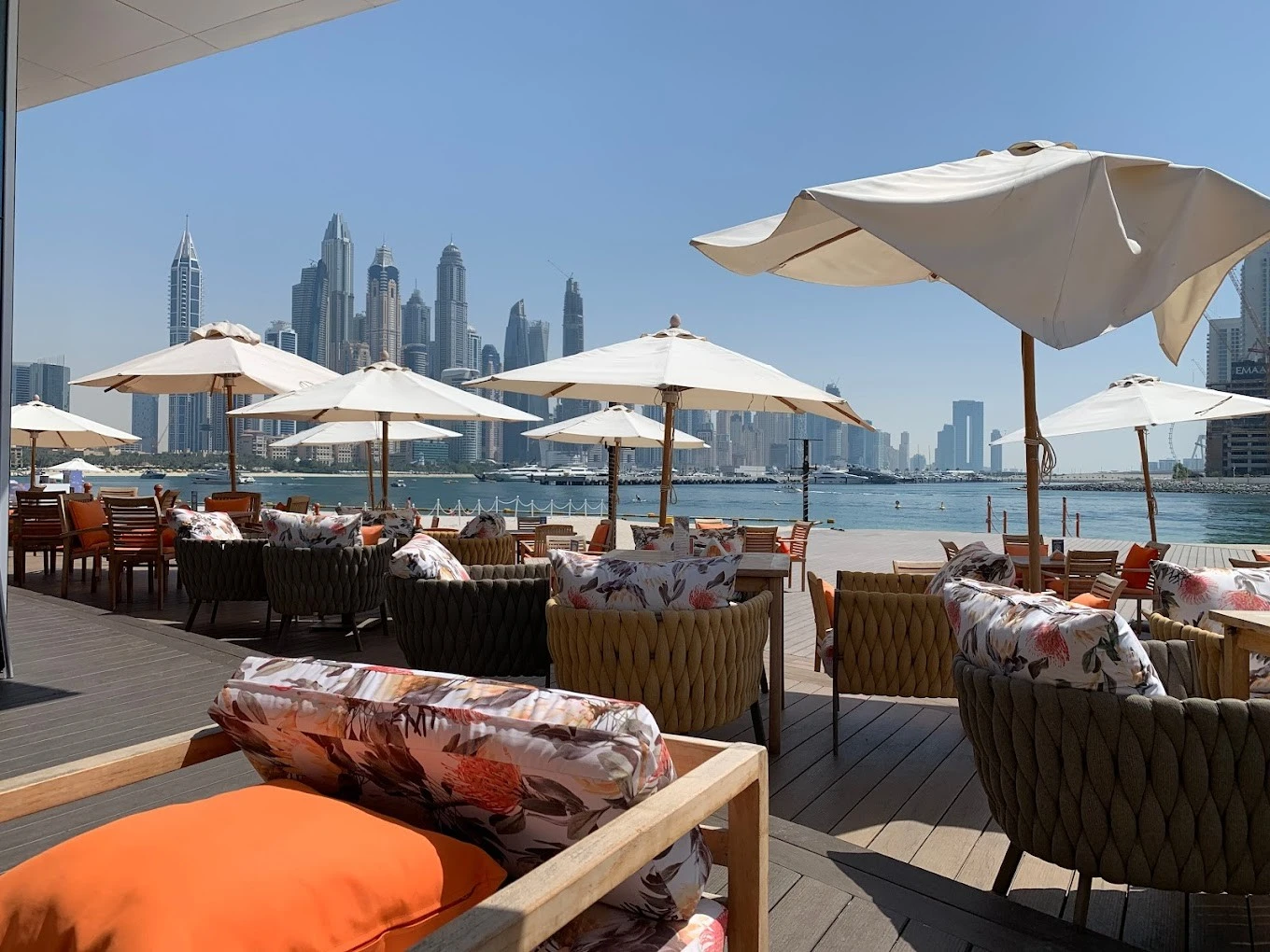 Outdoor terrace at Orange Chameleon, Dubai skyline and sea view.