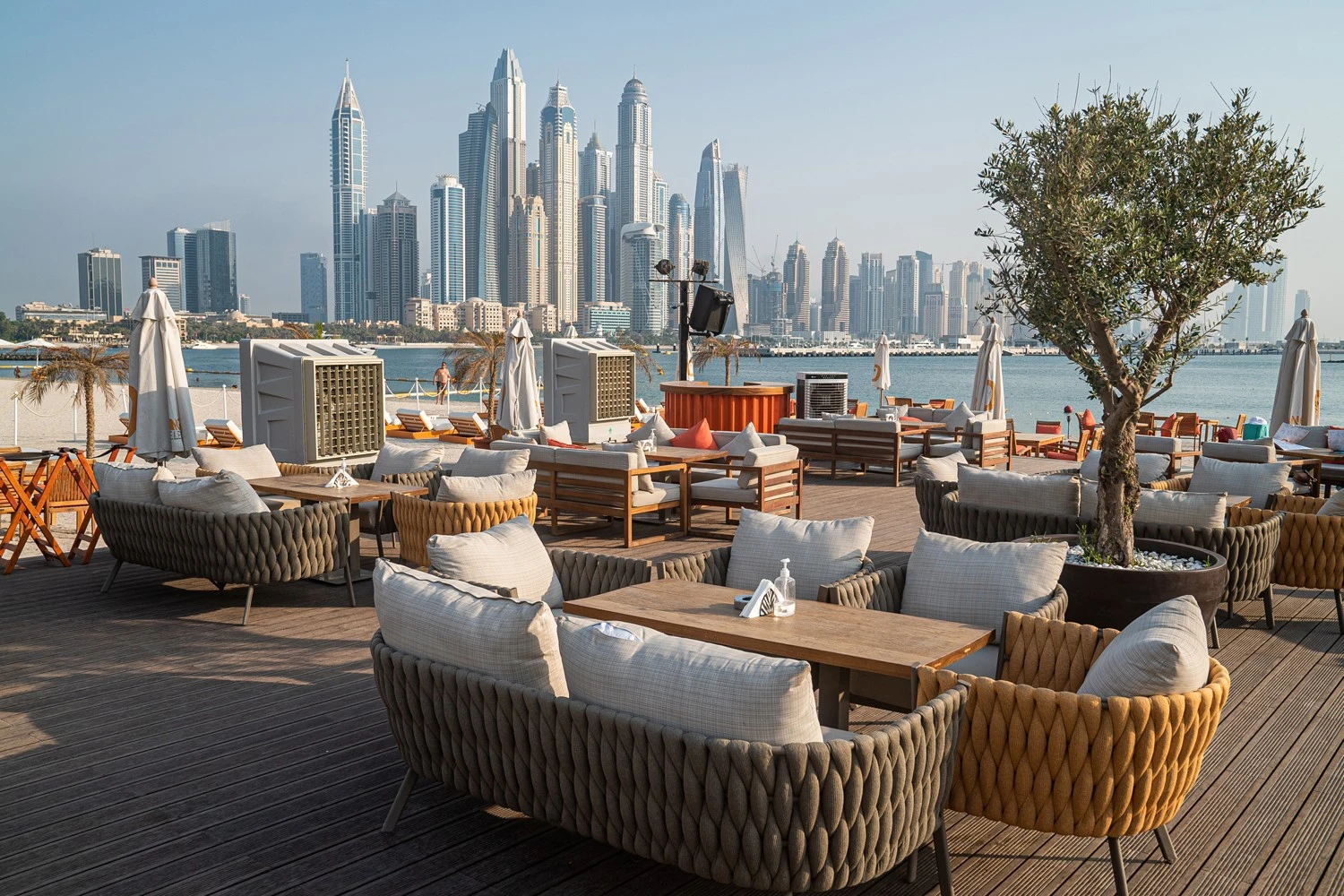 Outdoor seating at Orange Chameleon Restaurant, Dubai skyline view.