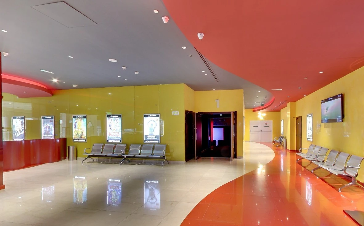 Colorful lobby with seating and movie posters, Star Cinema Al Ain.
