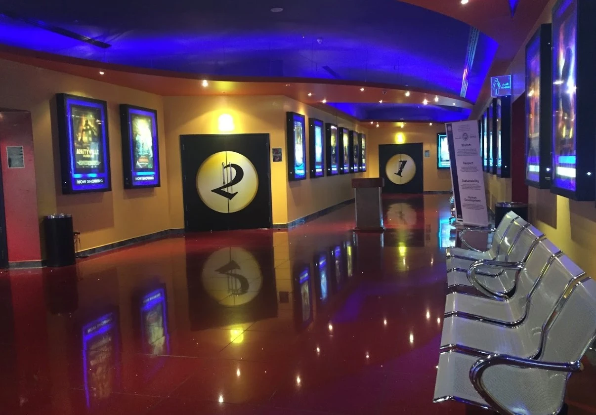Star Cinemas Al Ain Mall hallway with movie posters and seating.