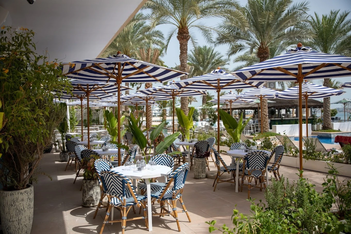 Outdoor seating with striped umbrellas at Byron Bathers Beach Club, Dubai.