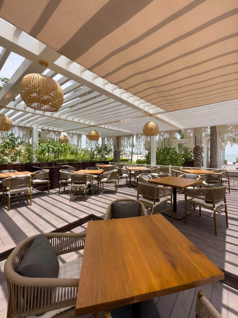 Outdoor seating at Cabana On The Beach Palm Dubai, shaded patio.