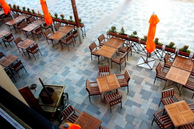Terrace dining with orange parasols at Al Bait Al Shami, Dubai.