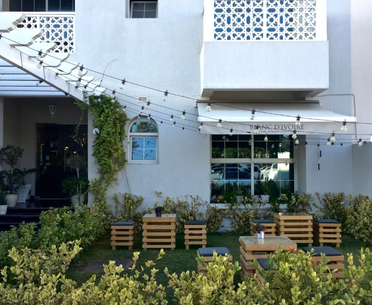 Outdoor seating at Fiks Coffee Umm Suqeim, Dubai with string lights.