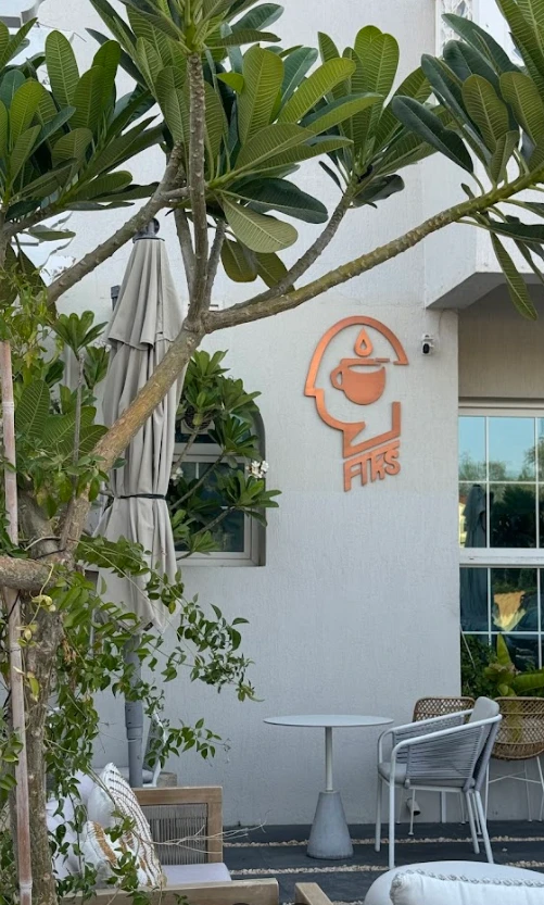 Outdoor seating at Fiks Coffee Umm Suqeim, Dubai with greenery.